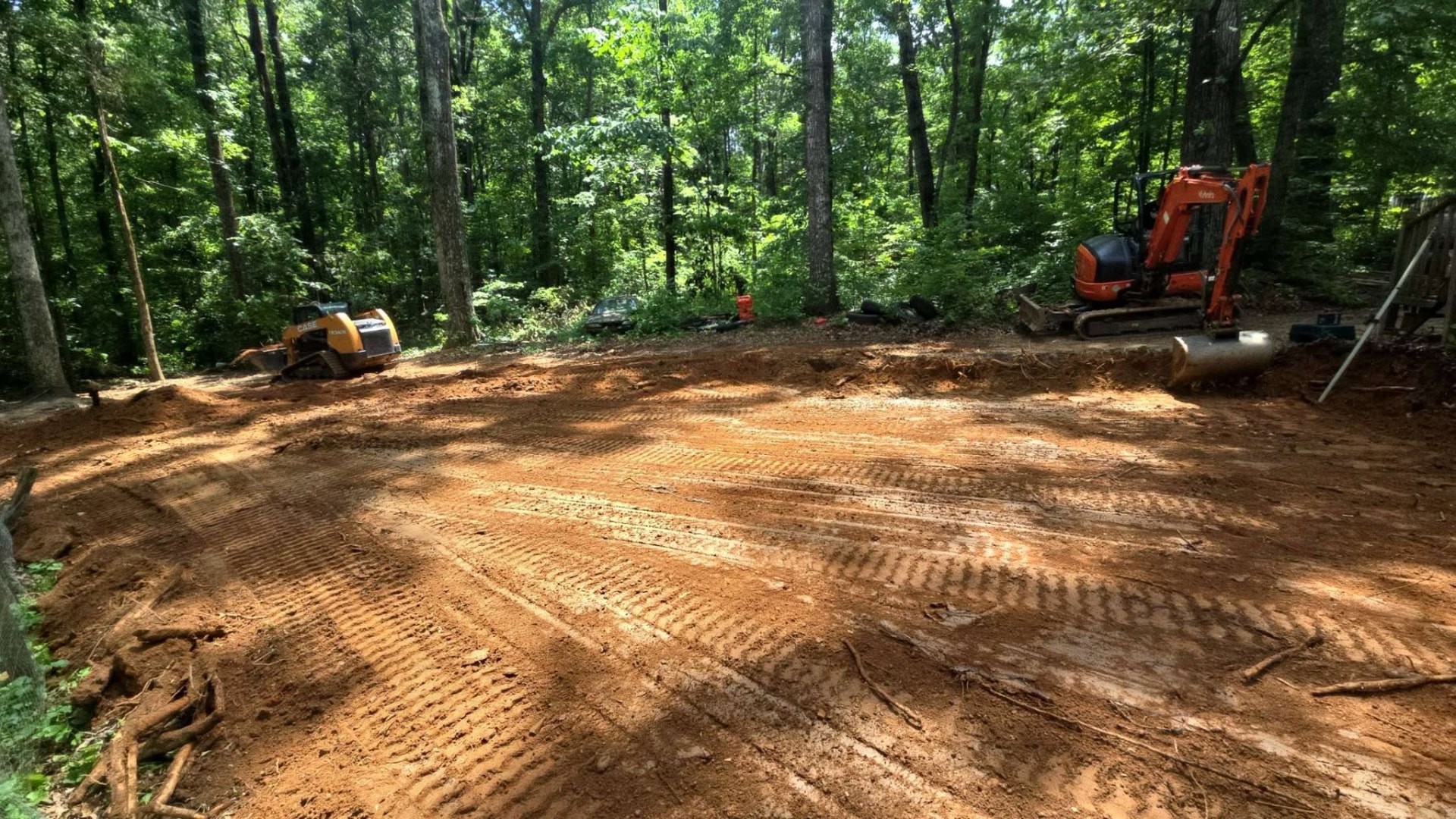 Land cleared with compact excavators working among the trees